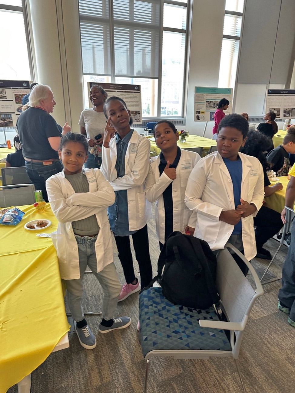 Amyrah, Mai'Lynn, Ayden and Waheed show off their white coats after completing the CHOP Science Academy program.