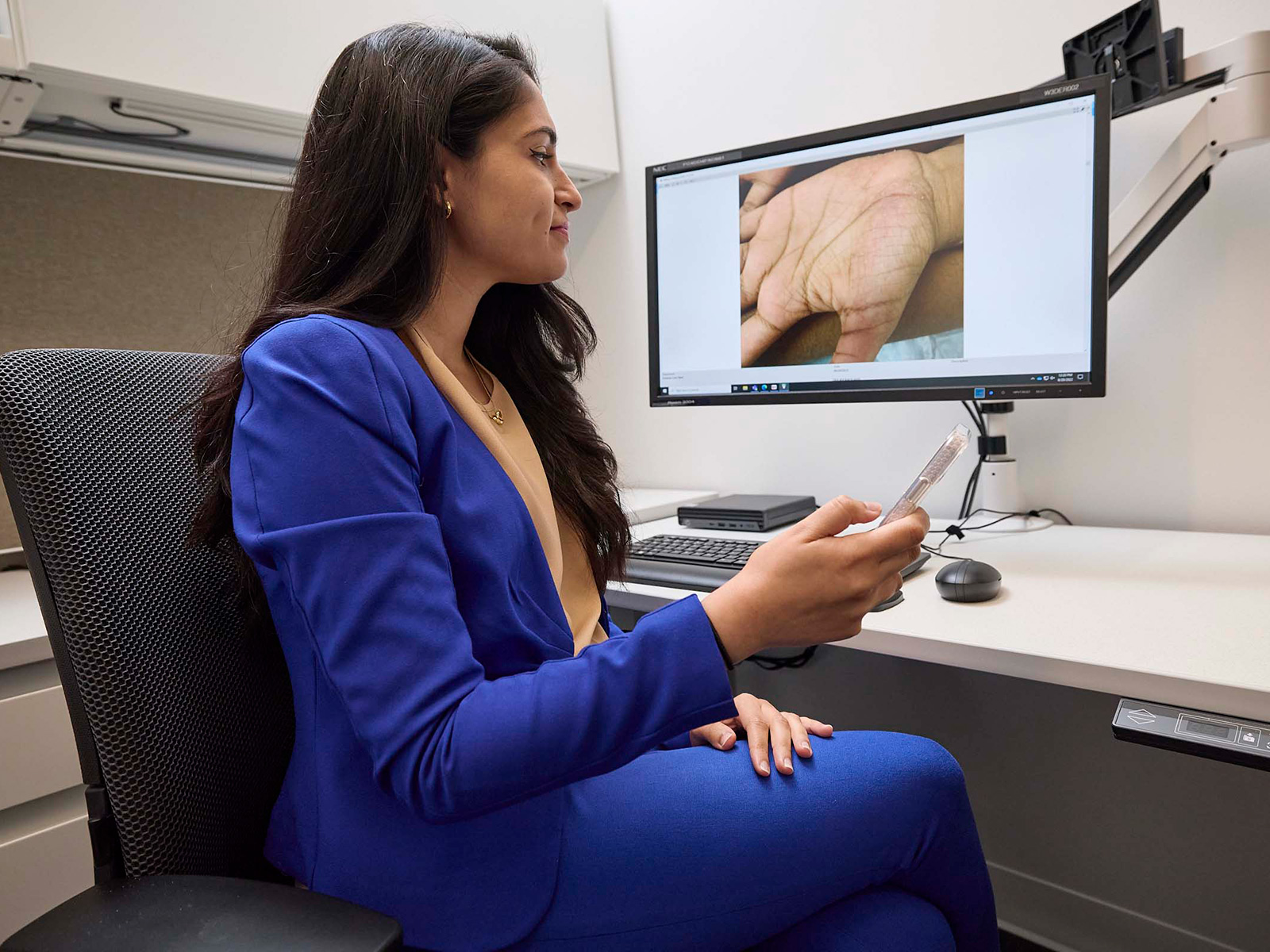 Physician reviewing an e-consult provided photo on a computer