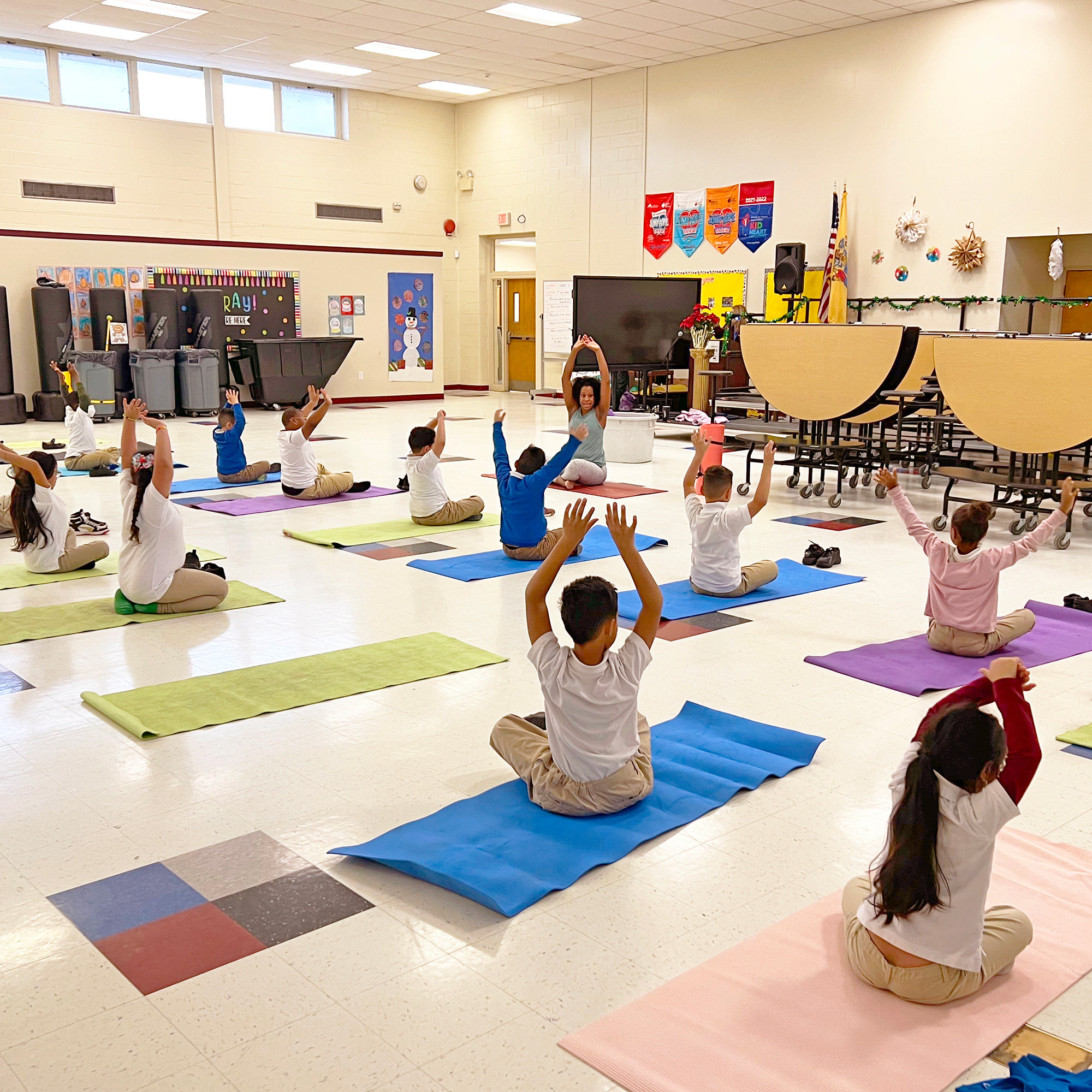 Schoolchildren practicing yoga in a school cafeteria