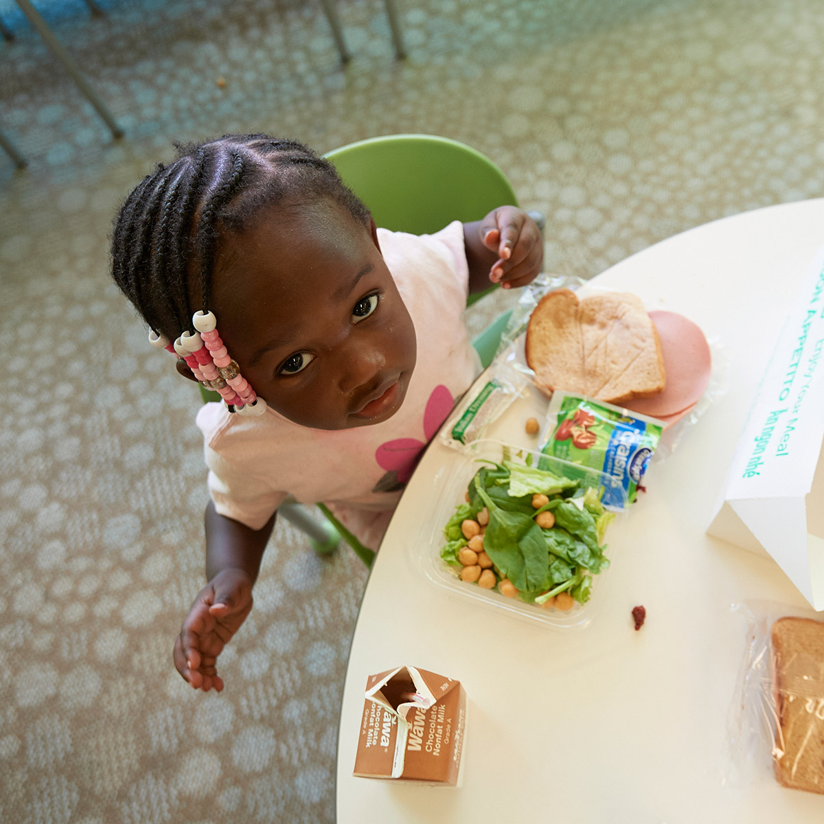 Young girl sitting at a table with a salad